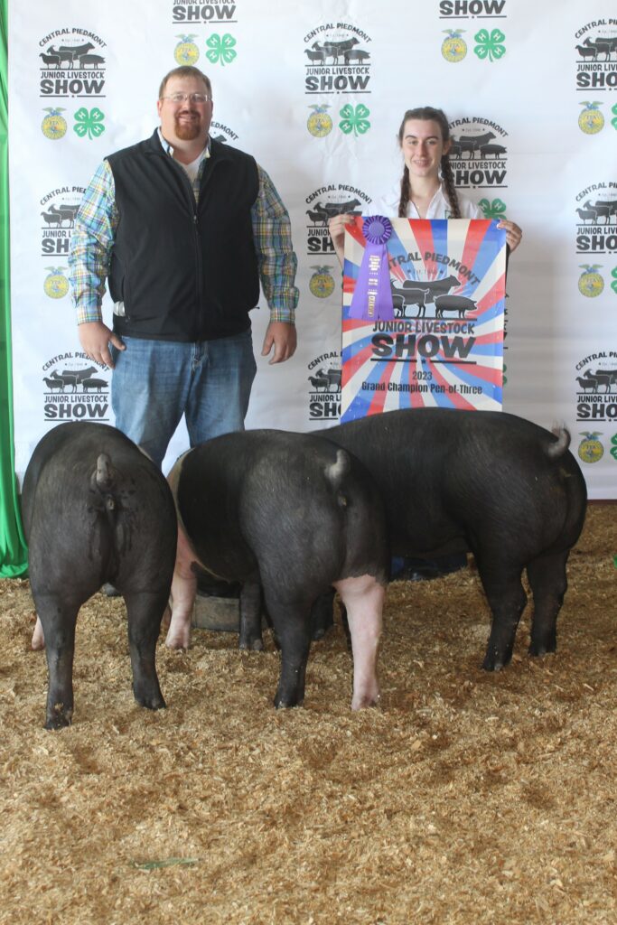 Sarah Beth holds up ribbon after participating in a livestock show with hogs