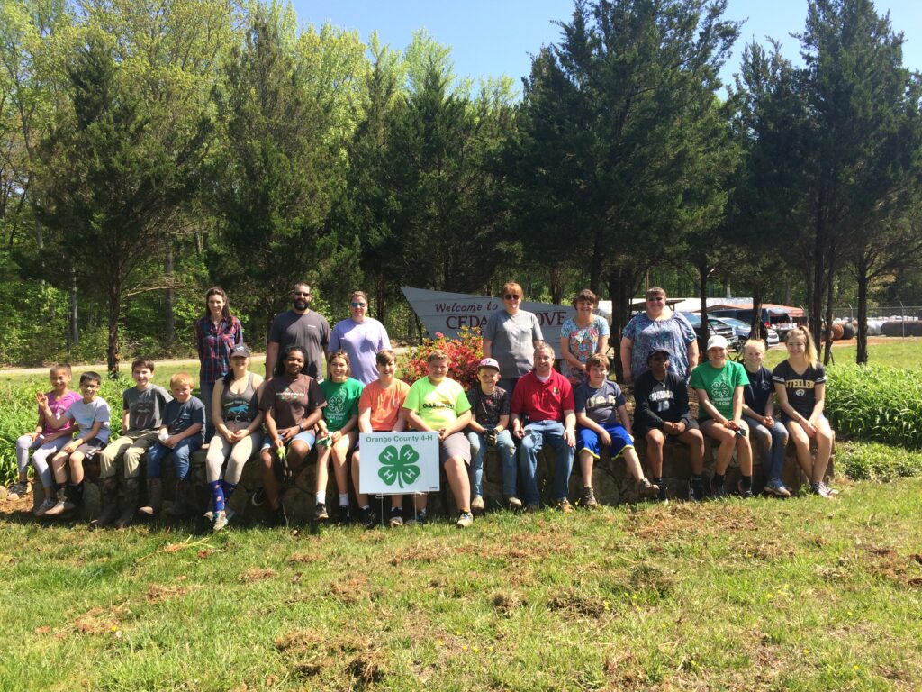 4-H volunteers with youth at Cedar Grove community sign on National 4-H Day of Service.